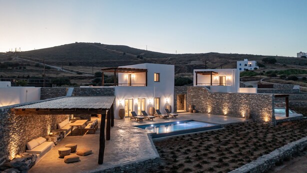 A modern villa with a swimming pool, stone walls, and outdoor seating. - Casa Botanica · Heather (Antiparos)