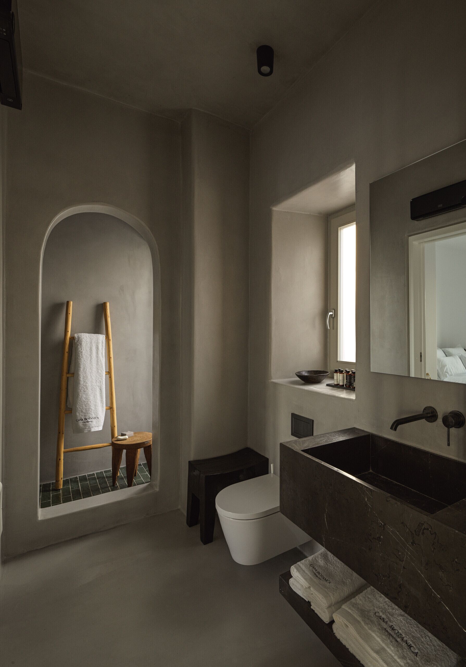 A modern bathroom with a large sink, a mirror, and a towel rack.