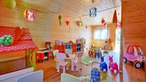 A brightly lit room with wooden walls, colorful chairs, and a variety of toys and decorations. - Elegant House with Terrace Near Sea (Karwia)