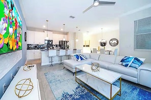 Ein modernes Wohnzimmer mit einem weißen Sofa, einem Couchtisch und einem Fernseher.
