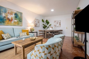 A modern living room with a sofa, coffee table, and patterned chairs. - Genteel Home Avenida America (Cordoba)