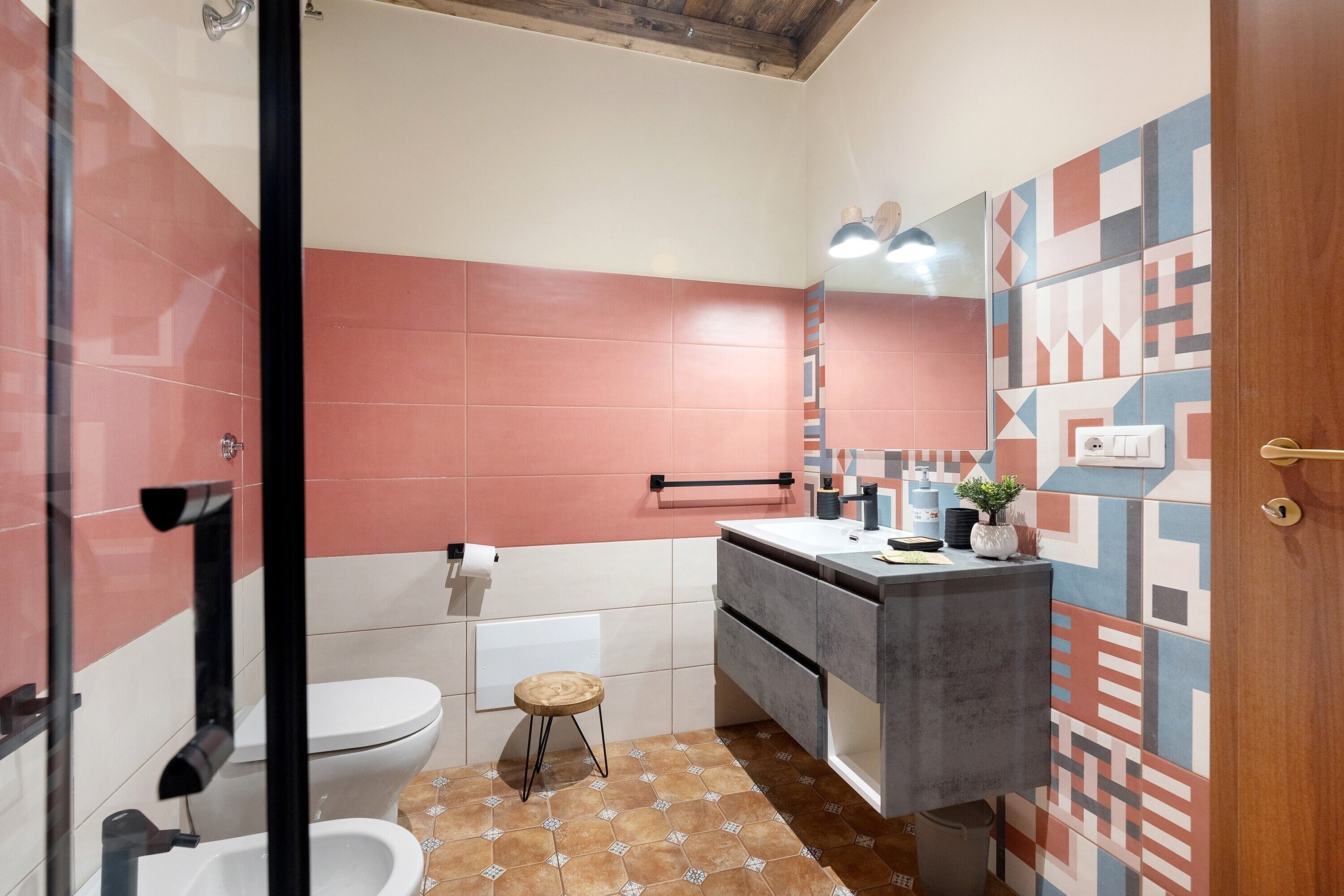Une salle de bain équipée de toilettes, d’un bidet, d’un lavabo et d’un miroir.