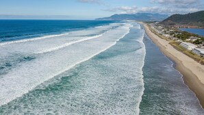 Ein Küstenblick mit Strand und einer Reihe von Häusern entlang der Uferlinie.