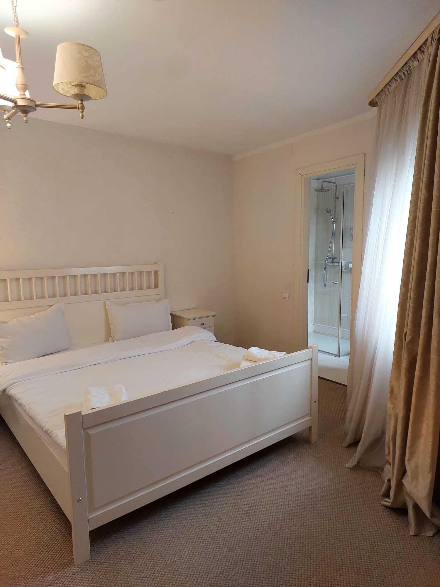 Une chambre à coucher avec un lit, une table de chevet et un espace douche.