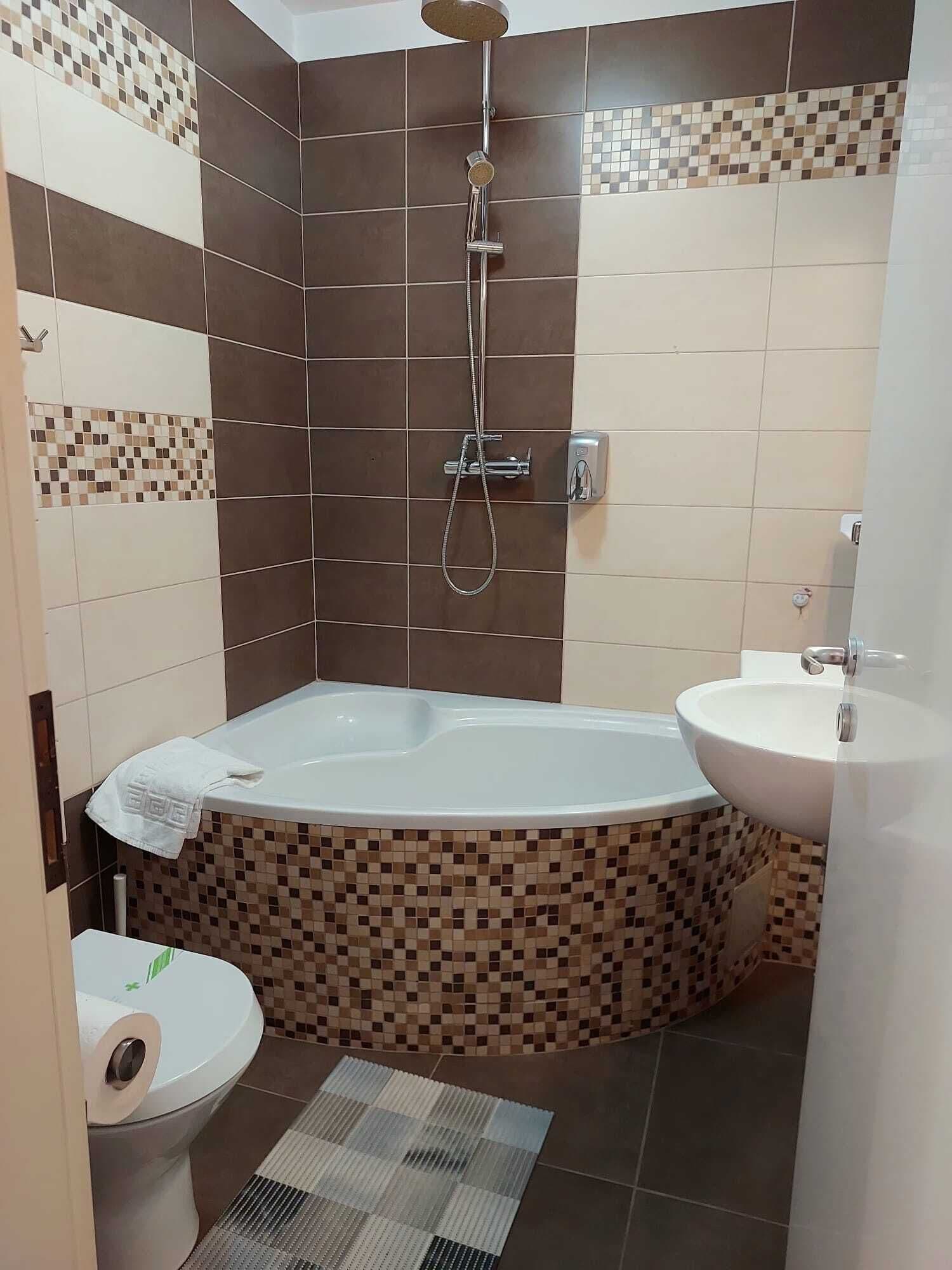 A bathroom with a bathtub, a shower, a toilet, and a sink.