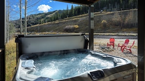 Ein Whirlpool mit Blick auf einen bewaldeten Hang.