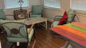 Un salon chaleureux avec une table en bois, des fauteuils turquoise et un chemin de table aux couleurs vives.