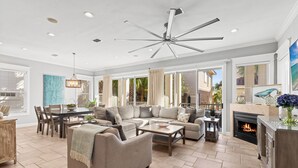 A spacious living room with a large sectional sofa, a fireplace, and a ceiling fan. - Games, Elevator, Ensuites, Pool, Bikes, Elevator (Destin)