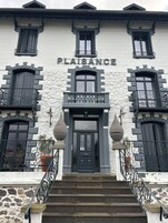 A building with a stone facade, a black entrance door, and the name "PLATSAANCE" above the door.