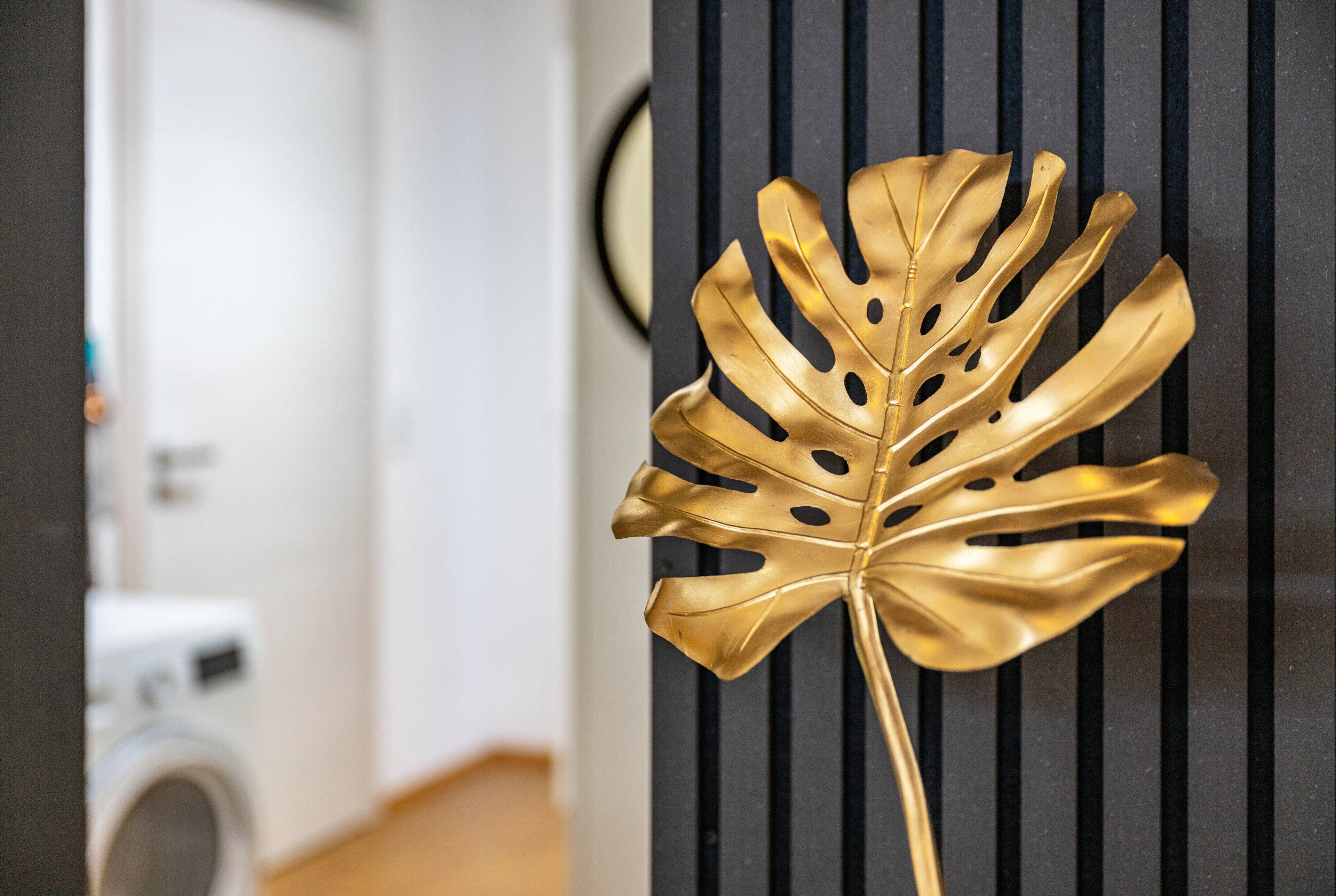 A gold decorative leaf against a black striped background.