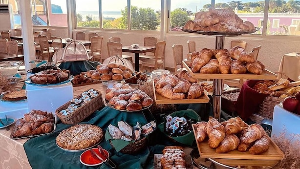A buffet with various baked goods and pastries spread across tables and serving boards. - Hotel Lo Smeraldo - Oasi degli Ulivi (Ventotene)