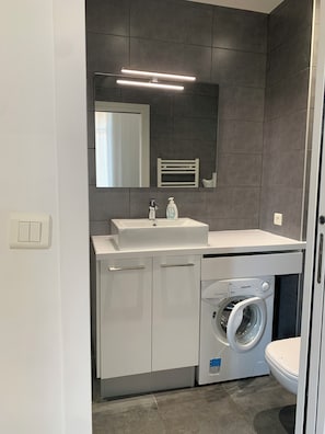 Regadera, secadora de cabello, toallas, papel de baño 