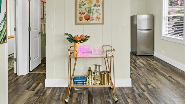 A kitchen with a wooden floor, a stainless steel refrigerator, and a wall-mounted fruit illustration. - Safety Harbor Motel (Safety Harbor)