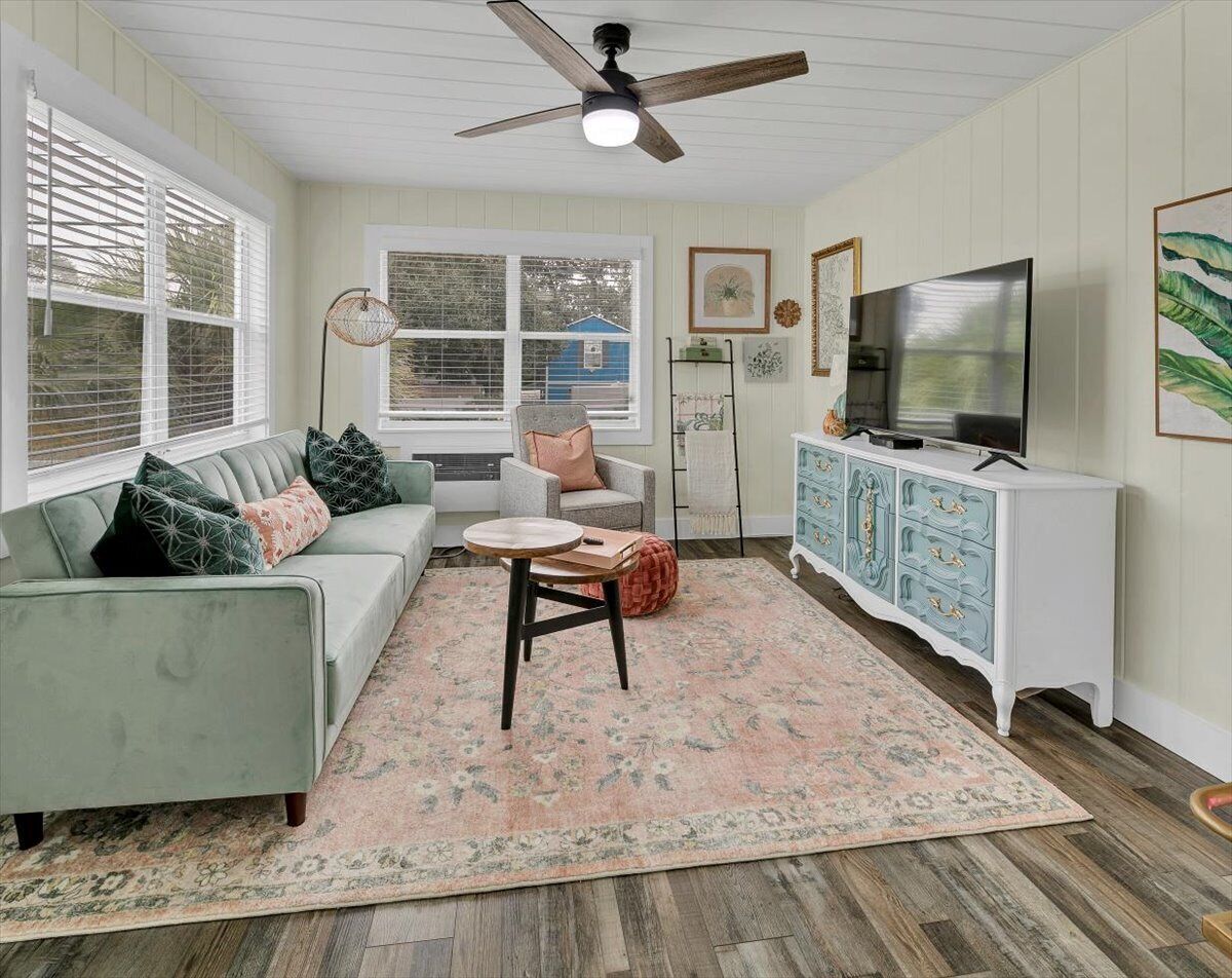 A living room with a sofa, a coffee table, a television, and a cabinet.