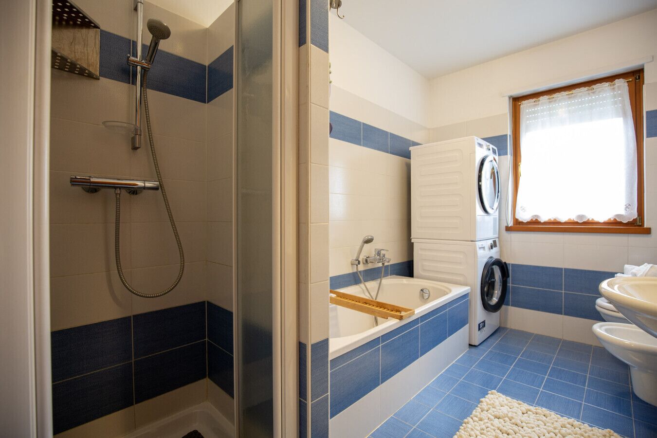 Kylpyhuone, jossa on suihku, kylpyamme, pesukone ja wc.
