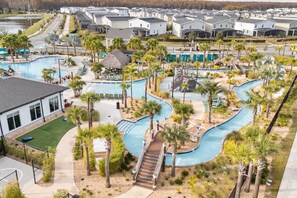 A residential area with a swimming pool, palm trees, and houses. - 9BD Sea-Themed - Pool + Resort Access, Near Disney (Kissimmee)