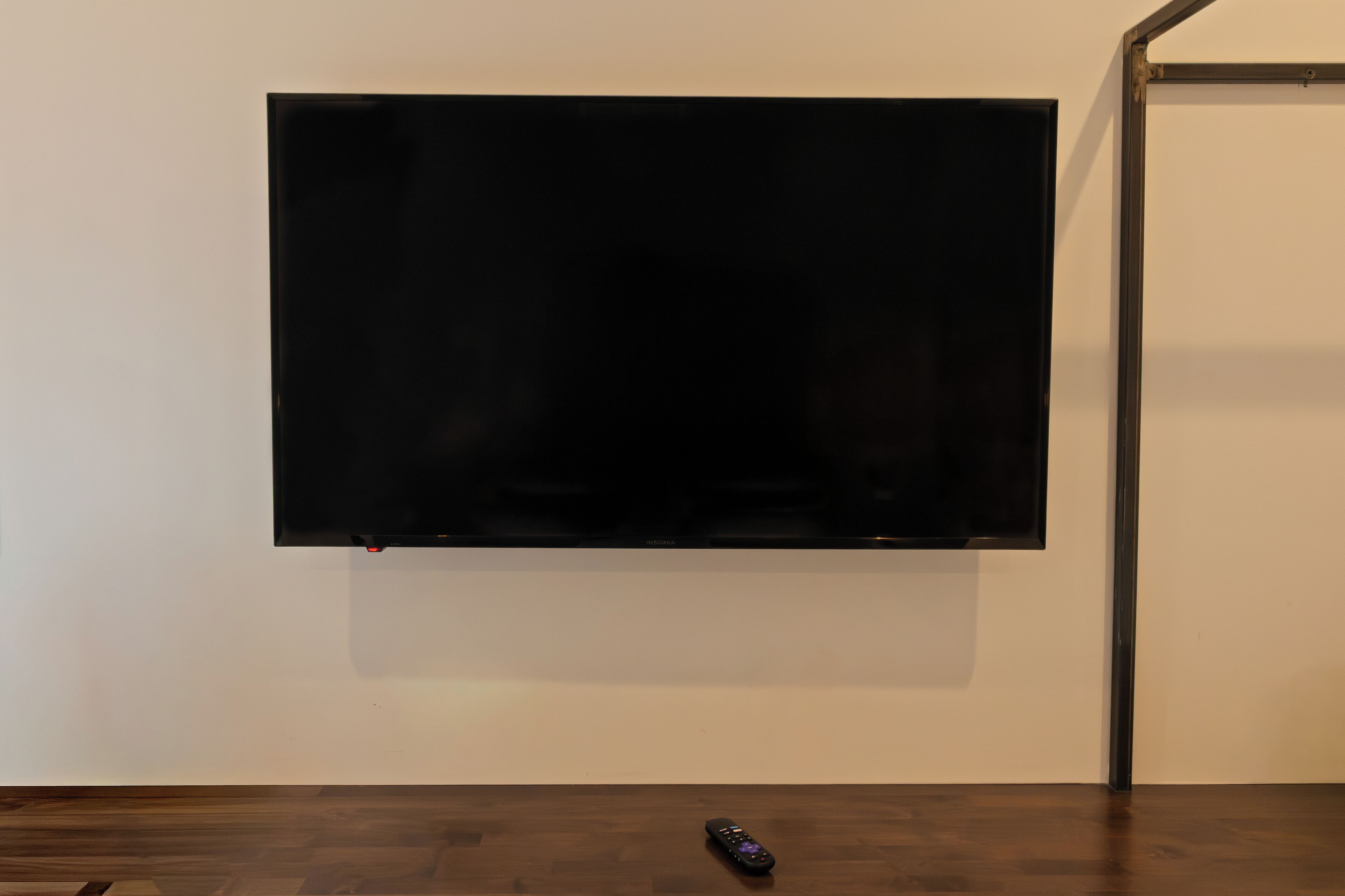 A flat-screen TV mounted on a white wall.