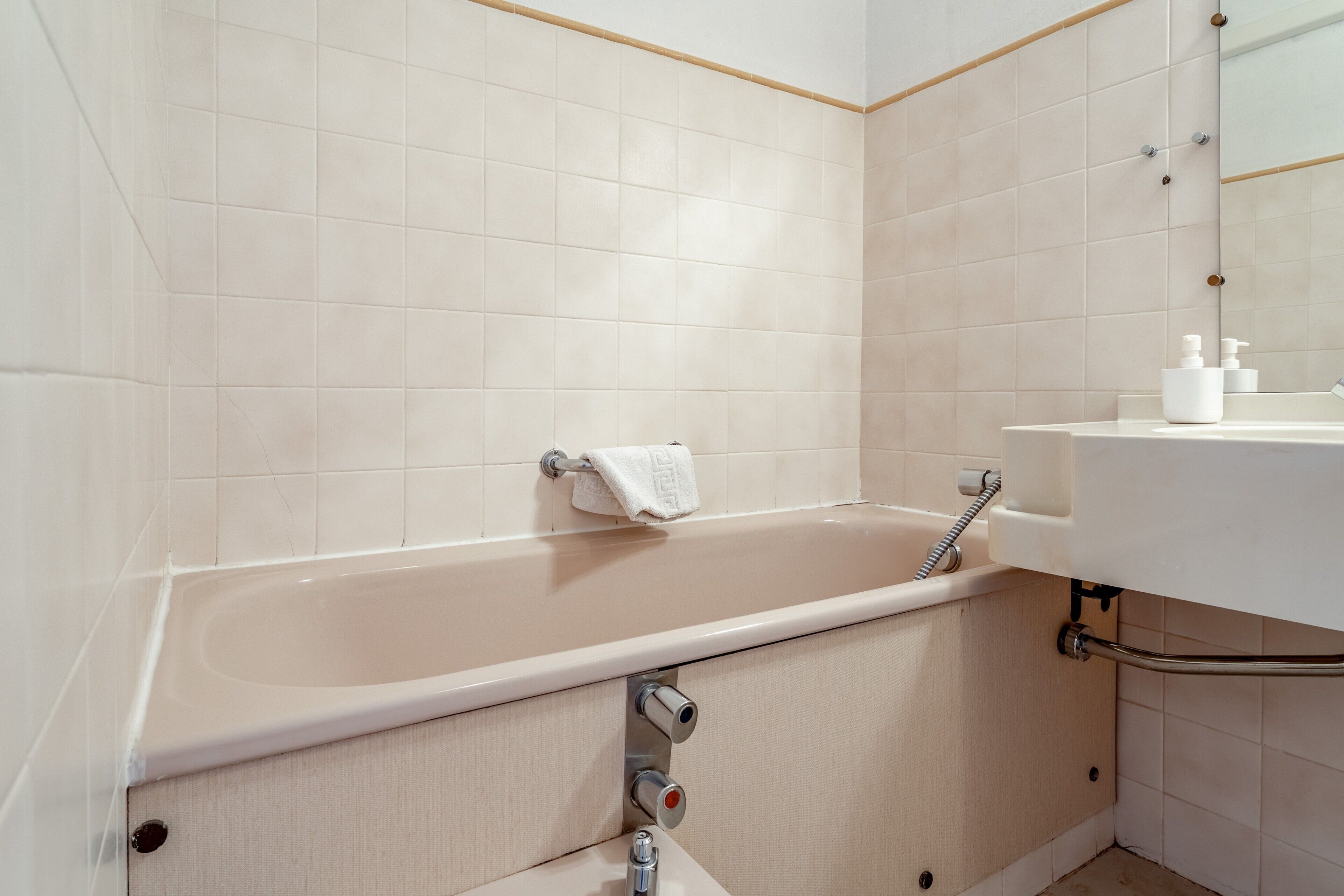 Un bagno con vasca, lavandino e specchio.