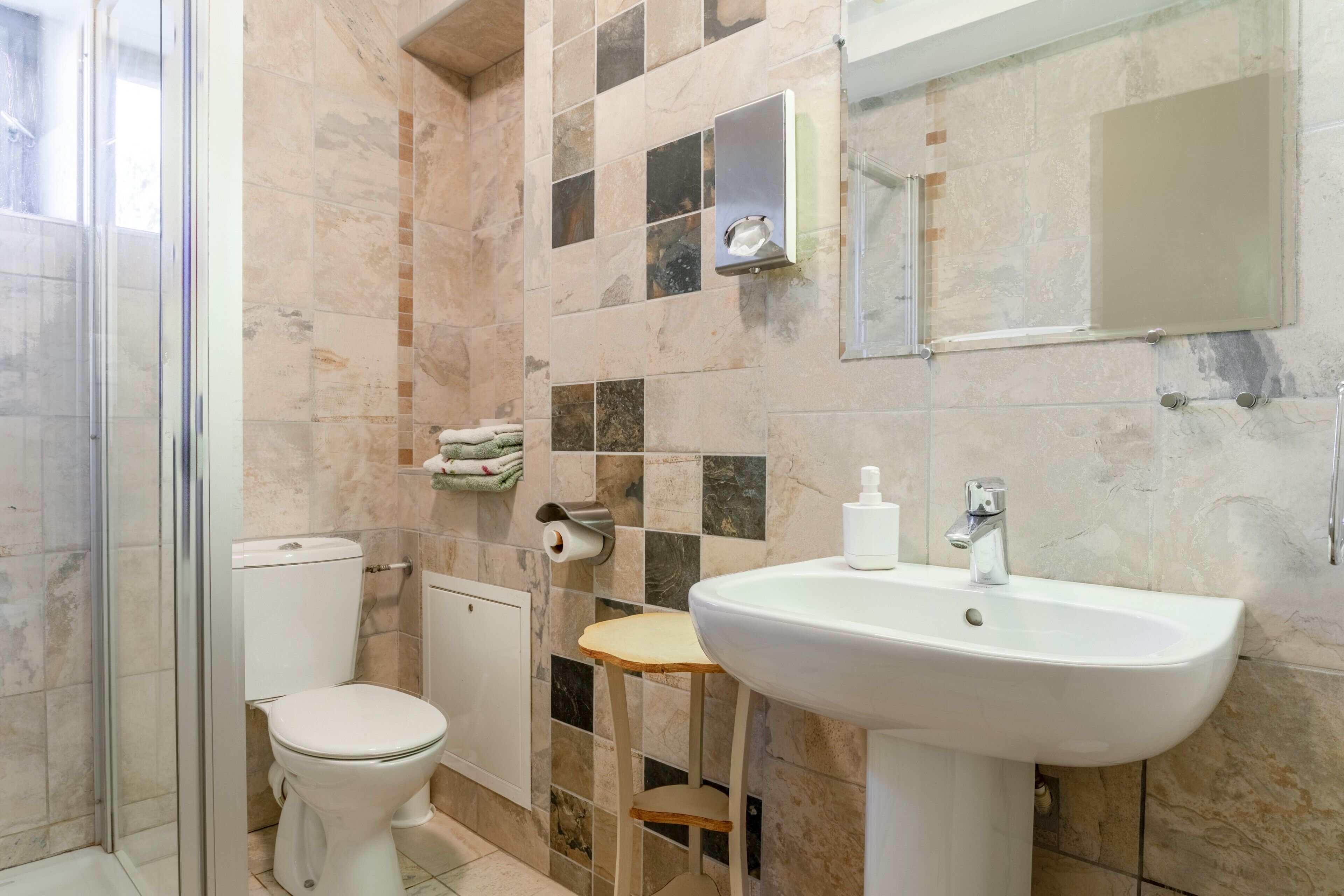 Un baño con inodoro, lavamanos y ducha.