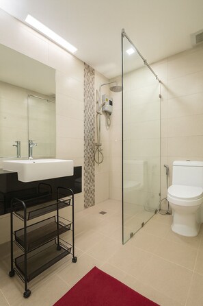A modern bathroom with a glass-enclosed shower, a white sink, and a toilet. - Cozy 2 Bedroom Condo in Pratumnak (Muang Pattaya)