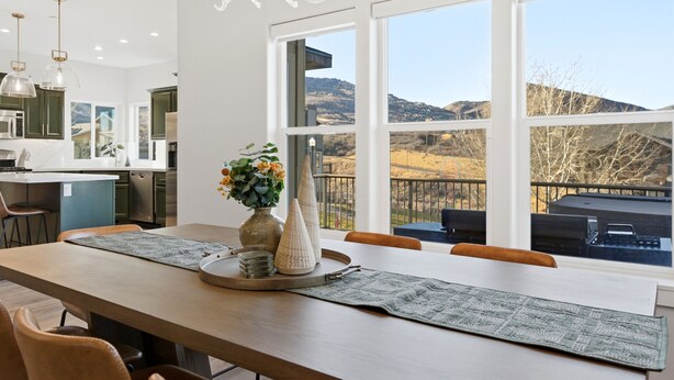 A modern kitchen with a large island, a dining area with a view of the mountains, and a chandelier. - HotTub+Sauna+Garage+DeerValleyEast+Jordanelle (Heber City)