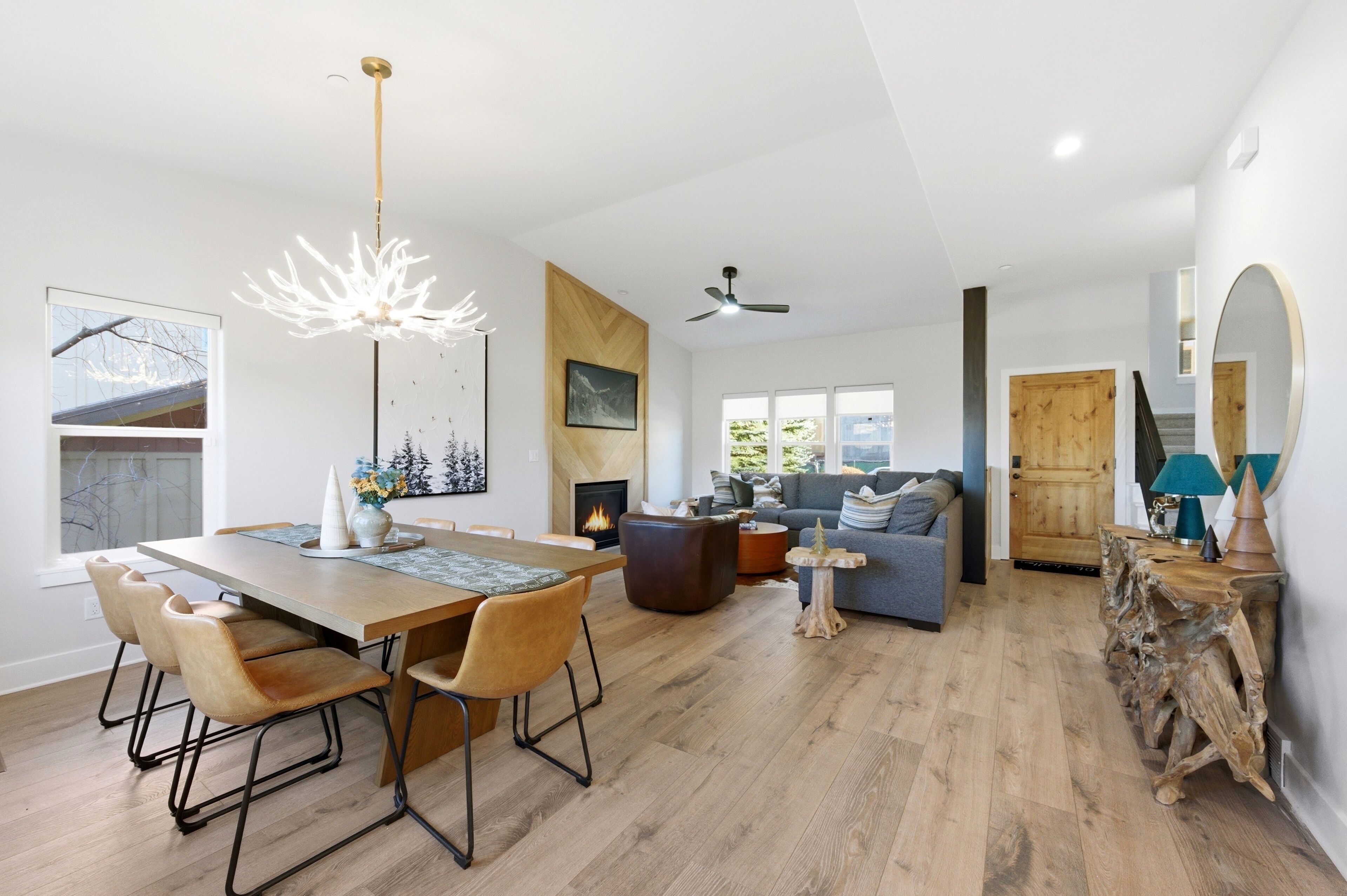 A spacious living area with a dining table, chairs, a sofa, and a fireplace.