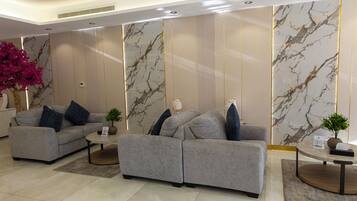 Un salón moderno con dos sofás grises, una mesita y plantas decorativas.