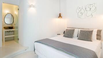 Un dormitorio con cama, mesita de noche, luz empotrada en la pared y un espejo.