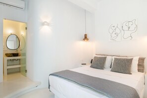Une chambre à coucher comprenant un lit, une table de chevet, une lampe fixée au mur et un miroir.