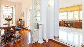 Una habitación amplia con una mesa de madera, sillas y un ventanal grande.