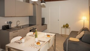 Una cucina moderna con zona pranzo, divano e lampada.