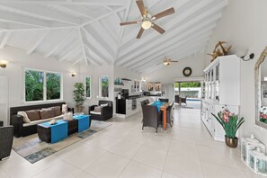 A spacious living area with a kitchen, dining area, and a large window offering a view of the outdoors. - Villa Kas Bon Bida at Marbella Estate (Willemstad)
