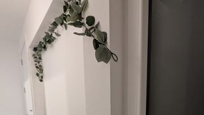 Een hal met een witte muur, een raam versierd met hartjes en een kleine plant.
