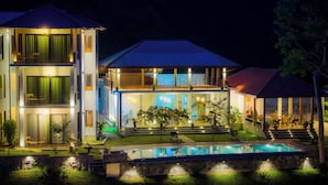 A two-story modern house with a swimming pool, outdoor seating, and a well-lit entrance. - River Shades Hotel (Hikkaduwa)