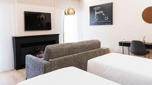A modern hotel room with a fireplace, two beds, a desk, and a television. - Le Suite del Corso (Lugo)
