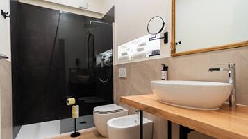 Une salle de bain moderne avec un grand lavabo blanc, un miroir et un espace douche.
