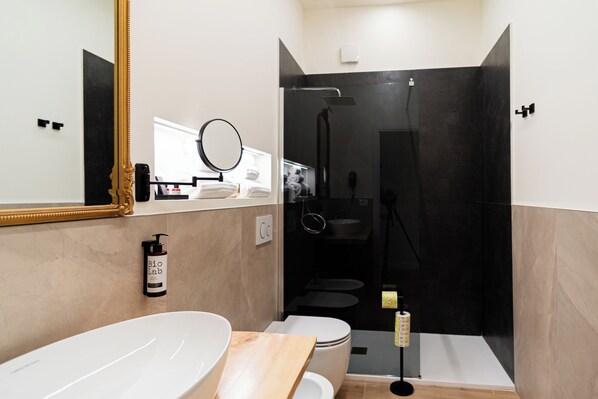 Ein modernes Badezimmer mit großem Spiegel, Waschbecken in Weiß, Toilette und einer Duschkabine.