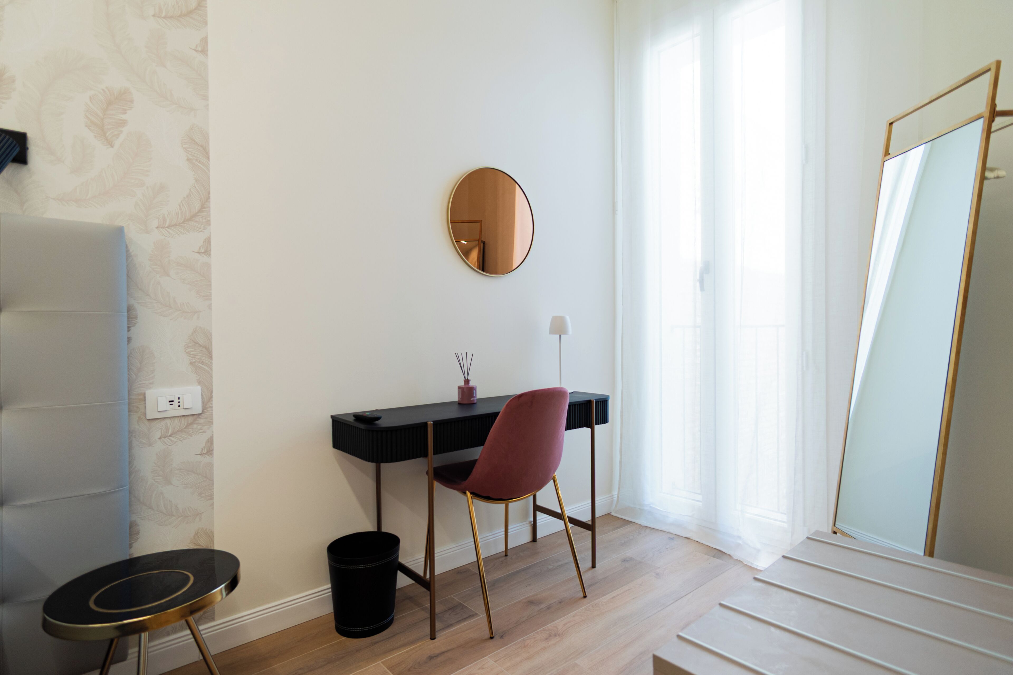 Una habitación con escritorio, silla y espejo.