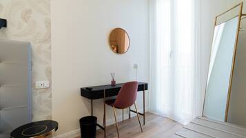 Una habitación con escritorio, silla y espejo.