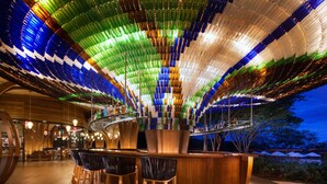 A bar area with a unique ceiling made of colorful bottles, wooden bar counter, and bar stools. - Spacious 3‑Bed Villa at Reserva Conchal (Cabo Velas)