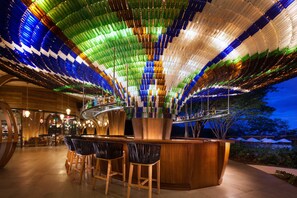 A bar area with a unique ceiling made of colorful bottles, wooden bar counter, and bar stools. - Spacious 3‑Bed Villa at Reserva Conchal (Cabo Velas)