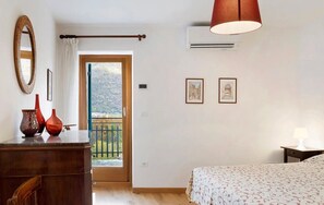 A bedroom with a bed, dresser, mirror, and artwork on the walls. - Room 'Unità 1' with Lake View, Wi-Fi, and Air Conditioning (Fratta)