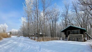 A snow-covered road with a cabin on the right. - Mini Chalet # 2  Domaine de l Archipel (Montérégie)