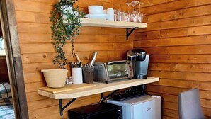 A compact kitchen with wooden walls, a microwave, toaster, coffee maker, and a small refrigerator. - Mini Chalet # 4  Domaine de l Archipel (Montérégie)