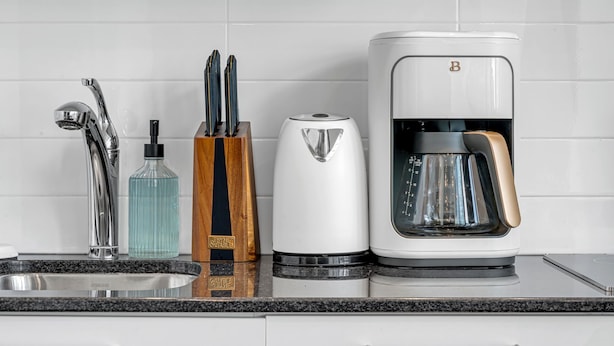 A modern kitchen with a stainless steel sink, a coffee maker, and a knife block. - Aurelien Toronto (Toronto)