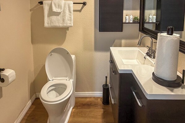A bathroom with a toilet, sink, mirror, and a towel rack. - Water purifier, Large Pool, outdoorTV dining grill (Rancho Cucamonga)