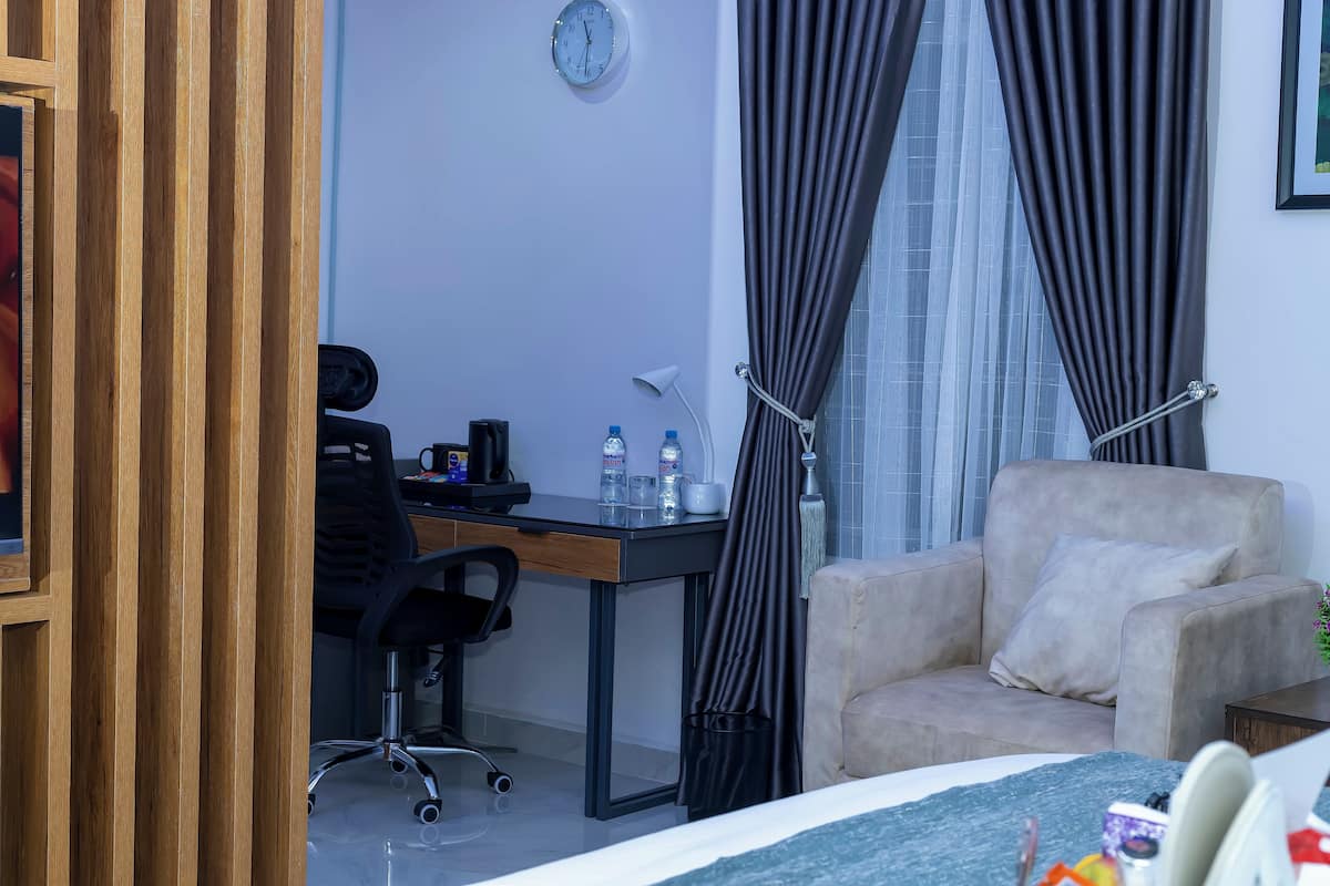 Une chambre d’hôtel équipée d’un bureau, d’une chaise et d’un canapé.