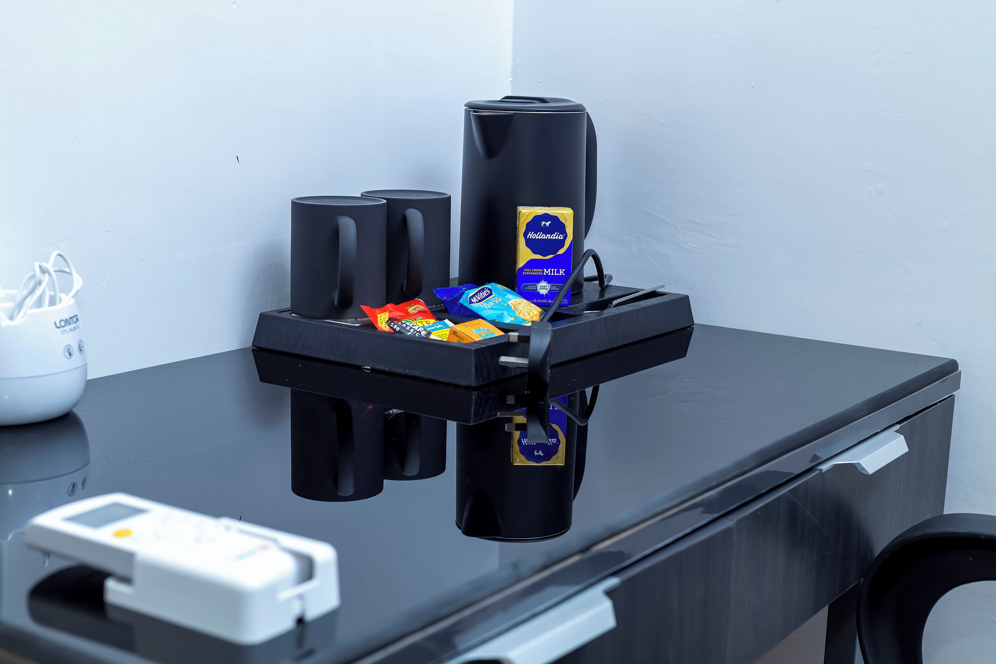 A coffee machine with a milk dispenser and a coffee maker on a black countertop.
