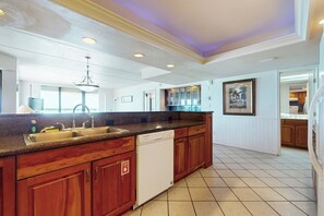 A kitchen with wooden cabinets, a dishwasher, and a granite countertop. - Luxury Perks, Corner 3BR: Suntide III - Unit 1001 (South Padre Island)