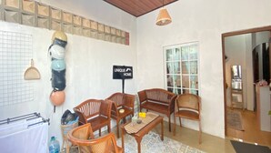 A cozy living area with wooden furniture, a tiled backsplash, and a sign reading "UNIQUE HOME". - Capital O 94840 Unihomestay Malioboro (Yogyakarta)